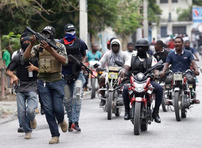 Armed off-duty police officers protest in Port-au-Prince, Haiti, on February 23, 2020. People identifying themselves as police officers committed an arson attack against local broadcaster Radio Télévision Caraïbes. (AP/Dieu Nalio Chery)