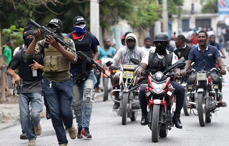 Armed off-duty police officers protest in Port-au-Prince, Haiti, on February 23, 2020. People identifying themselves as police officers committed an arson attack against local broadcaster Radio Télévision Caraïbes. (AP/Dieu Nalio Chery)