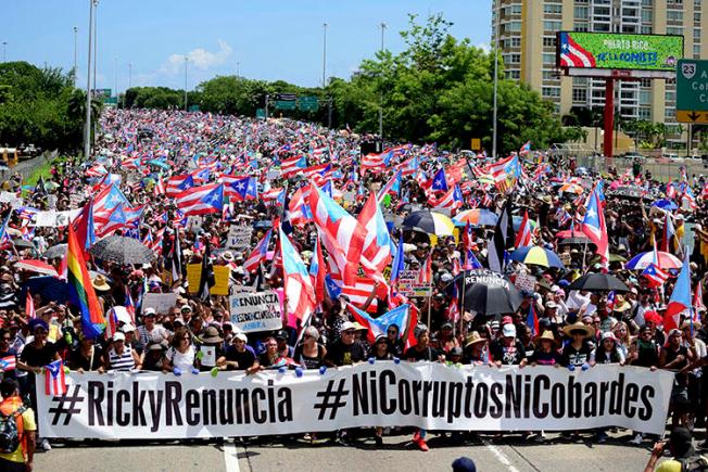 Demonstrators march on Las Americas highway demanding the resignation of Governor Ricardo Rossello, in San Juan, Puerto Rico, on July 22, 2019. Rossello resigned in early August, but first signed two laws that obstruct the work of investigative journalists in Puerto Rico. (AP Photo/Carlos Giusti)