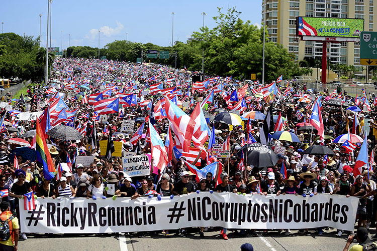 Demonstrators march on Las Americas highway demanding the resignation of Governor Ricardo Rossello, in San Juan, Puerto Rico, on July 22, 2019. Rossello resigned in early August, but first signed two laws that obstruct the work of investigative journalists in Puerto Rico. (AP Photo/Carlos Giusti)
