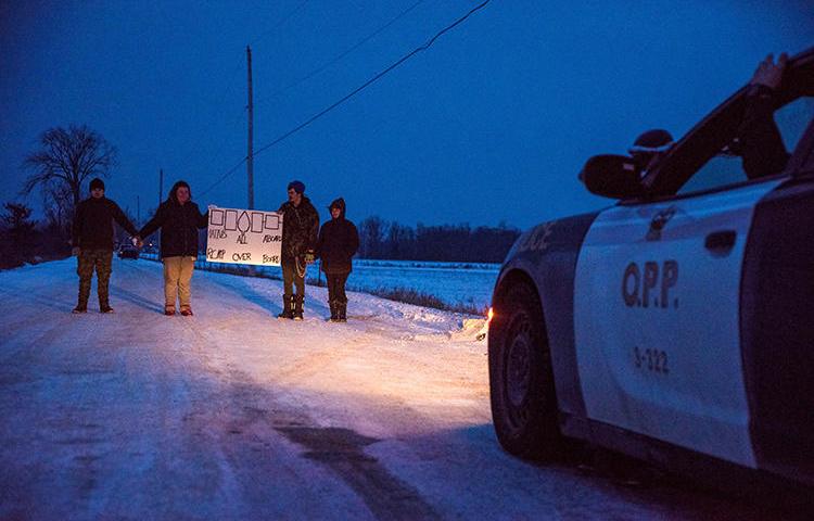 People block train tracks as part of a protest against British Columbia's Coastal GasLink pipeline, in Tyendinaga, Canada, on February 9, 2020. Police recently obstructed and detained journalists covering the protests. (Reuters/Alex Filipe)