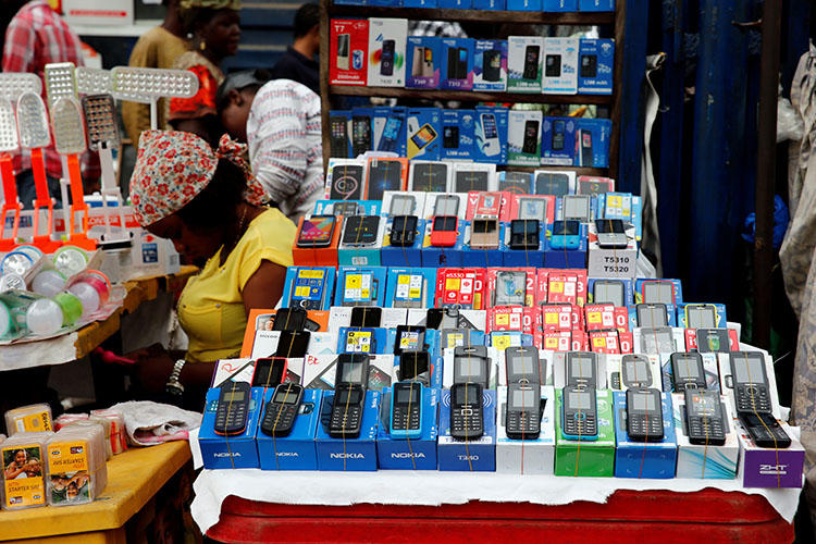 A woman vendor waits for customers as she uses her phone at the 'Computer Village' in Ikeja district in Nigeria's commercial capital Lagos on May 31, 2017. Nigeria’s police have used telecom surveillance to lure and arrest journalists. (Reuters/Akintunde Akinleye)