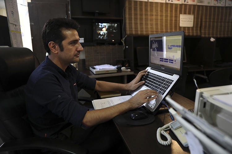 An internet cafe manager works on his computer in Tehran, Iran on July 25, 2019. Iranian journalists say monitored connections and technology companies' concerns about U.S. government sanctions are making it harder for them to bypass censorship. (AP/Vahid Salemi)