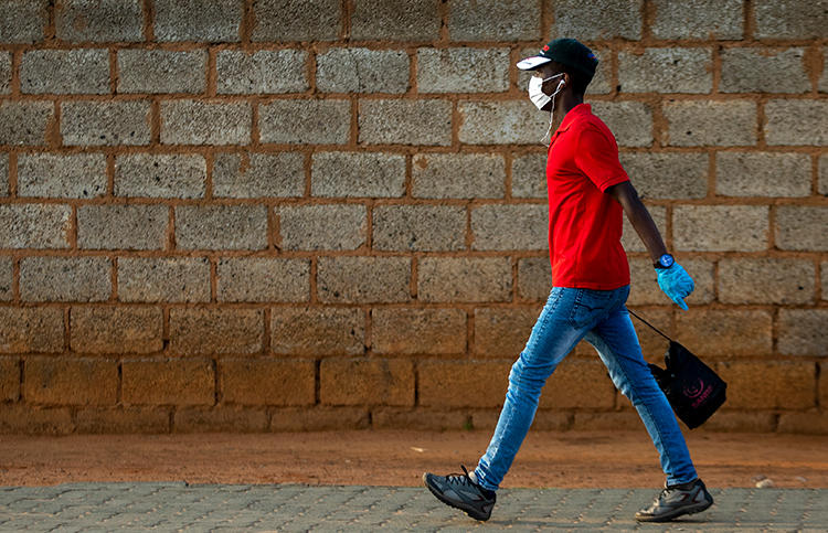 A man wearing a surgical mask and gloves to protect himself from the coronavirus, walks on a street in Soweto, South Africa, Thursday, March 19, 2020. For most people the virus causes only mild or moderate symptoms. For others it can cause more severe illness, especially in older adults and people with existing health problems. (AP/Themba Hadebe)