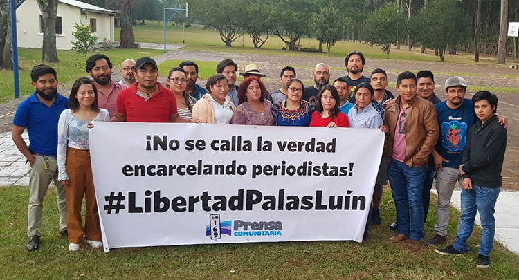 Journalists from Prensa Comunitaria hold a sign reading 'Jailing journalists does not silence the truth.' Reporters in Guatemala's remote regions are at higher risk of harassment, threats, or attacks. (Nelton Rivera/Prensa Comunitaria)