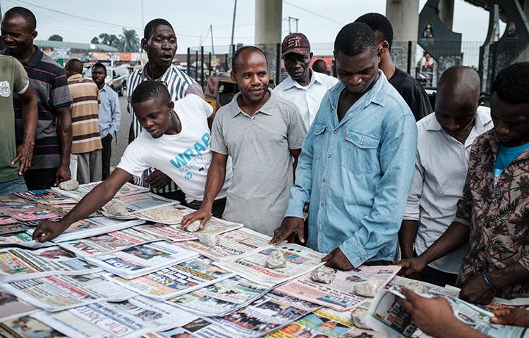 People are seen at a newspaper stand in Port Harcourt, Nigeria, on February 27, 2019. Nigerian journalists at the Premium Times recently faced cyberattacks and harassment. (AFP/Yasuyoshi Chiba)