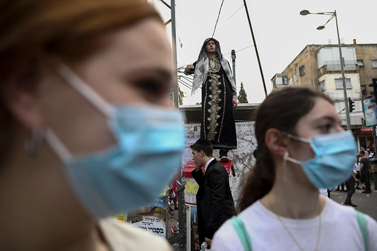 Ultra-Orthodox Jewish girls wear face masks during celebrations of the Purim festival in Bnei Brak, Israel, on March 10, 2020. CPJ recently spoke with Laura Adkins, an Orthodox Jewish editor at the Jewish Telegraph Agency. (AP/Oded Balilty)