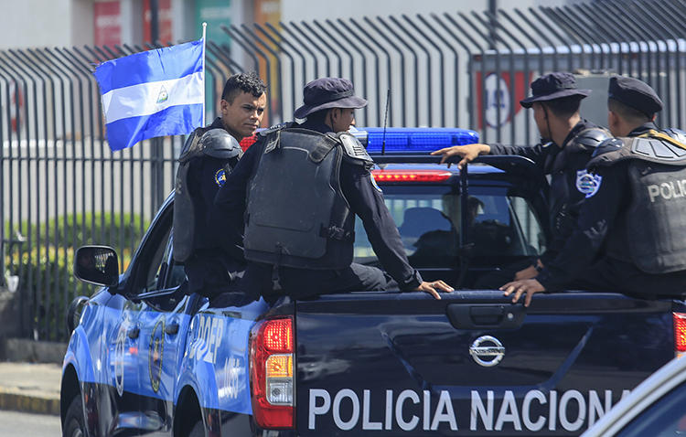 National Police officers are seen in Managua, Nicaragua, on August 24, 2019. National Police have been surveilling and harassing journalist Emiliano Chamorro. (AP/Alfredo Zuniga)