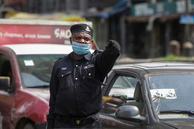 A police officer is seen at a roadblock in Lagos, Nigeria, on March 31, 2020. The Nigerian government recently imposed restrictions on journalists' movement and access to stem the COVID-19 pandemic. (AP/Sunday Alamba)