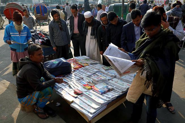 People read newspapers in Dhaka, Bangladesh, on January 30, 2019. Journalist Shafiqul Islam Kajol recently went missing after he was named in a criminal defamation suit. (Reuters/Mohammad Ponir Hossain)