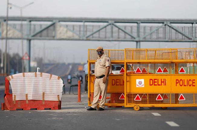 A police officer stands at a barricade in New Delhi, India, on March 23, 2020. Police in New Delhi and Hyderabad recently assaulted journalists for allegedly violating the cities' lockdowns. (Reuters/Adnan Abidi)