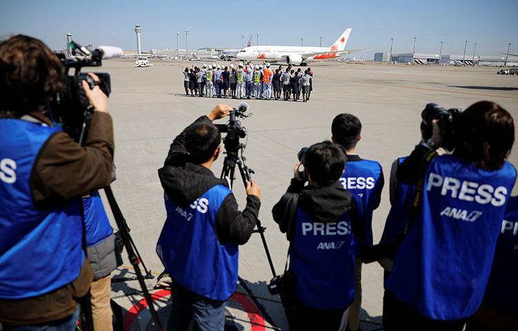 Members of the media watch as the Olympic Flame is transported to Japan, at Haneda international airport in Tokyo on March 18, 2020. CPJ recently joined a call for transparency and press freedom at the Olympics and other major sporting events. (Reuters/Issei Kato)