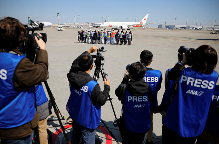 Members of the media watch as the Olympic Flame is transported to Japan, at Haneda international airport in Tokyo on March 18, 2020. CPJ recently joined a call for transparency and press freedom at the Olympics and other major sporting events. (Reuters/Issei Kato)