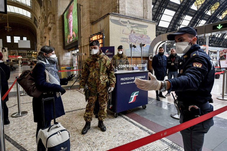 Police officers and soldiers check passengers at Milan's main train station in the north of Italy on March 9, 2020. (Claudio Furlan/LaPresse via AP)