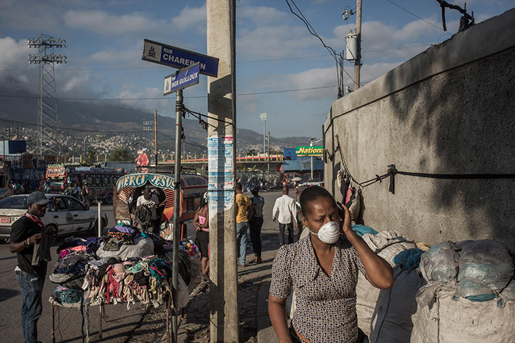 Une femme se promène dans le centre-ville de Port-au-Prince (Haïti), le 26 mars 2020. Huit journalistes ont été agressés récemment en couvrant la pandémie de coronavirus à Port-au-Prince. (AFP/Pierre Michel Jean)