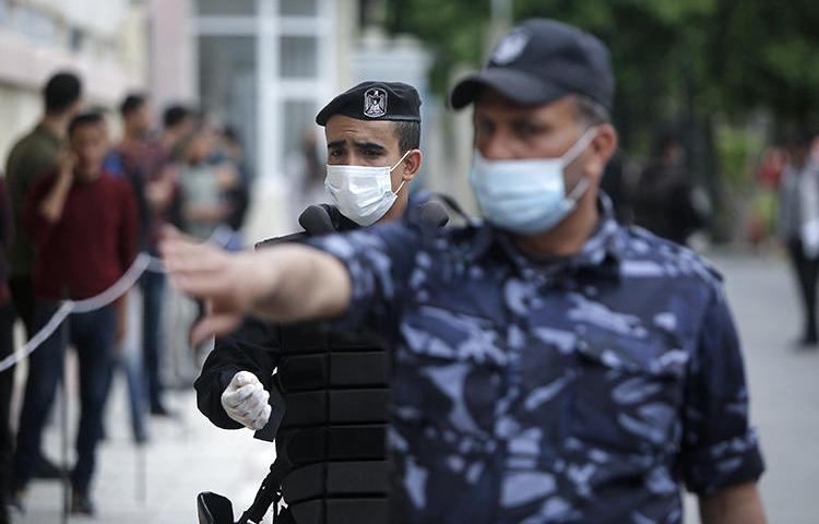 Police are seen in Gaza City on March 31, 2020. Police in Gaza recently arrested Palestinian cartoonist Ismael el-Bozom. (AFP/Mohammed Abed)