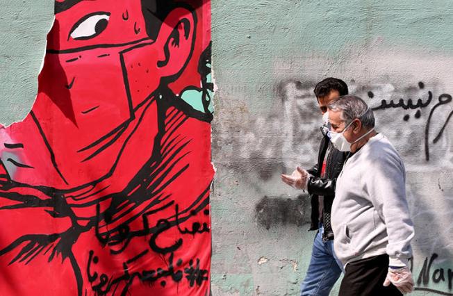 People walk in Tehran, Iran, on April 13, 2020. Two Iranian universities recently filed suits against journalists for their coverage of the COVID-19 pandemic. (AFP/Atta Kenare)
