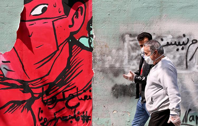 People walk in Tehran, Iran, on April 13, 2020. Two Iranian universities recently filed suits against journalists for their coverage of the COVID-19 pandemic. (AFP/Atta Kenare)