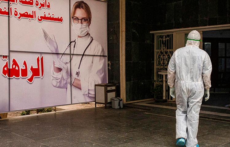 A medical worker is seen at Basra University Hospital, in southern Iraqi, on April 1, 2020. Iraq's media regulator recently suspended Reuters' license for three months over a report on the COVID-19 pandemic. (AFP/Hussein Faleh)
