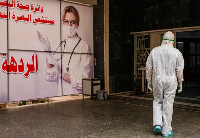 A medical worker is seen at Basra University Hospital, in southern Iraqi, on April 1, 2020. Iraq's media regulator recently suspended Reuters' license for three months over a report on the COVID-19 pandemic. (AFP/Hussein Faleh)
