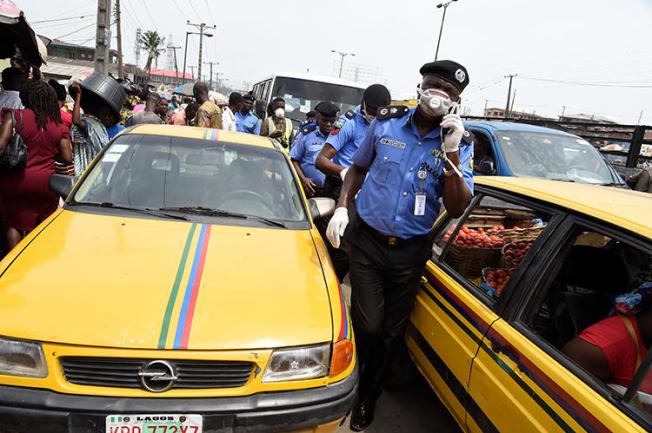 A police officer is seen in Lagos, Nigeria, on March 26, 2020. Police recently arrested two journalists for their work in Ebonyi state. (AFP/Pius Utomi Ekpei)