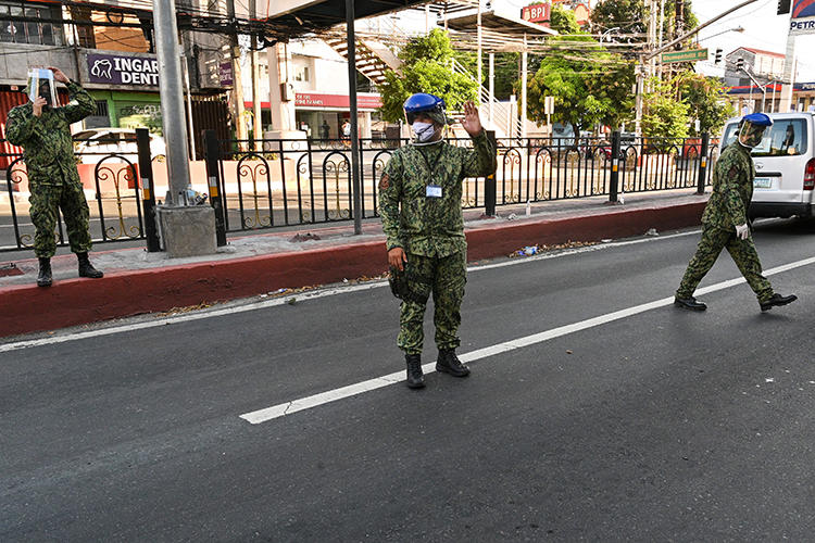 Police officers are seen in Manila, the Philippines, on March 25, 2020. National police recently filed a criminal complaint on behalf of Cavite City authorities against two journalists for spreading 'false information' about COVID-19. (AFP/Ted Aljibe)