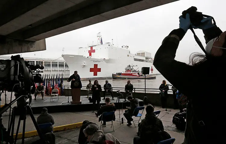 A journalist records a press briefing following the arrival of the USNS Comfort, a naval hospital ship with a 1,000 bed-capacity at Pier 90 in New York, on March 30, 2020. (AP Photo/Kathy Willens, File)