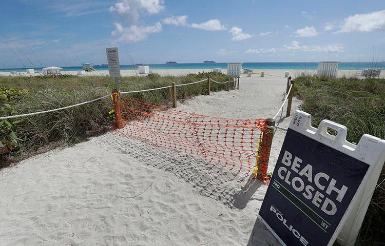 An entrance to a beach is closed on March 31, 2020, in Miami Beach, Florida. (AP Photo/Wilfredo Lee)