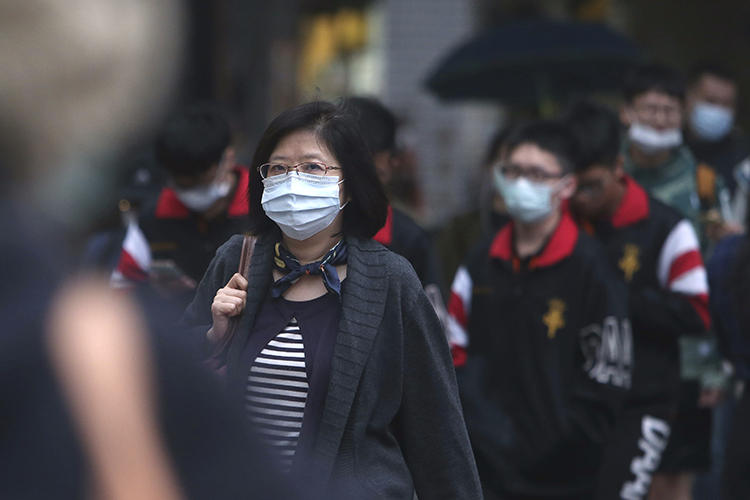 People walk on a street in Taipei, Taiwan, on March 30, 2020. CPJ recently spoke with journalist Brian Hioe on covering COVID-19 in Taiwan. (AP/Chiang Ying-ying)