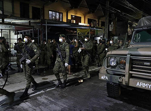 Soldiers wear masks in the Philippines, where the government has imposed criminal penalties for spreading “false news” about the pandemic. (AP/Aaron Favila)