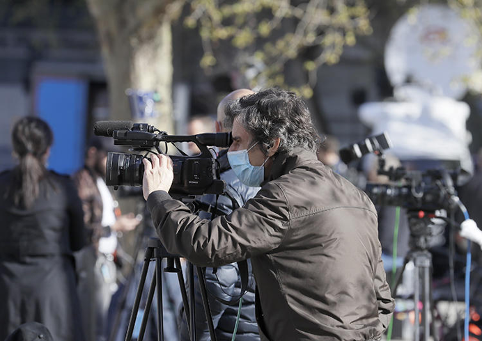 A masked journalist is seen in London on April 7, 2020. As journalists face the challenges of covering COVID-19, CPJ and other organizations are working to assess the global impact. (AP/Kirsty Wigglesworth)