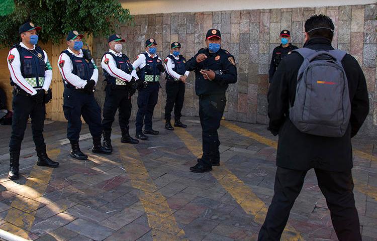 Police officers are seen in Mexico City on May 16, 2020. An unidentified man recently threatened to bomb the Mexico City offices of the Reforma newspaper. (AFP/Claudio Cruz)