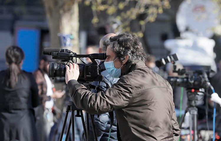 Journalists are seen in London on April 7, 2020. CPJ recently partnered with groups launching surveys to track the COVID-19 pandemic's impact on journalism. (AP/Kirsty Wigglesworth)