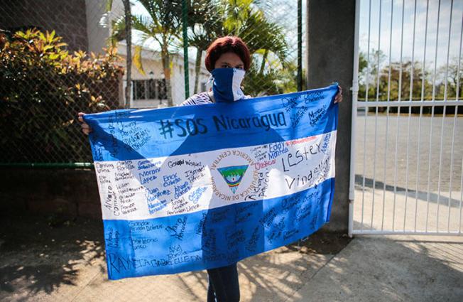 A protester holds a national flag during a demonstration against President Daniel Ortega's government in Managua, Nicaragua, on February 25, 2020. YouTube has censored independent Nicaraguan news outlets after copyright complaints from Ortega-owned media. (Reuters/Oswaldo Rivas)