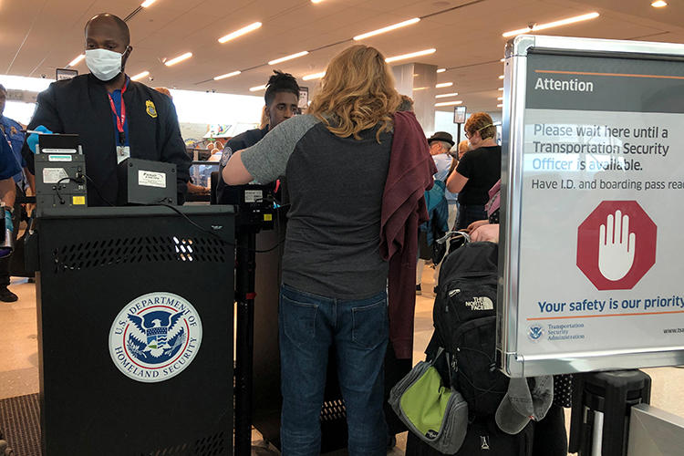 A U.S. Department of Homeland Security officer checks passports in Fort Lauderdale, Florida, on March 15, 2020. The department recently imposed new restrictions on Chinese nationals working as journalists in the United States. (Reuters/Teresa Barbieri)