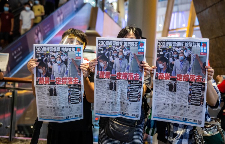 Hong Kong people hold Apple Daily newspaper