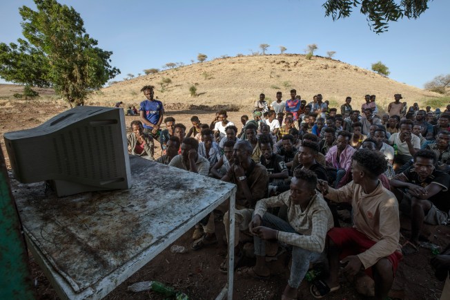 Tigranyan men who fled Ethiopia watch TV news