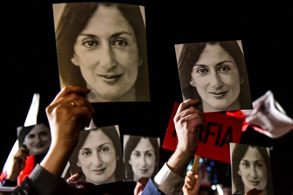 People hold photos of killed journalist Daphne Caruana Galizia during a protest called by Galizia's family and civic movements on November 29, 2019, outside the prime minister’s office in Valletta, Malta. (Photo by AFP)