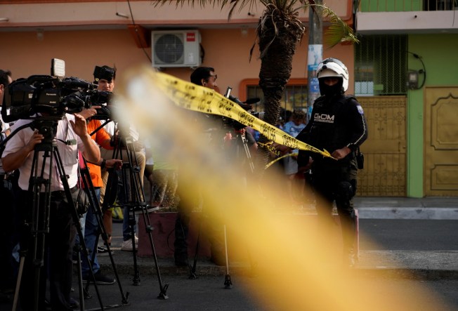 Journalists stand behind police tape at a crime scene in Guayaquil, Ecuador, on November 1, 2022. (Reuters/Santiago Arcos)