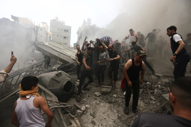 Palestinians remove a dead body from the rubble of a building after an Israeli airstrike Jebaliya refugee camp, Gaza Strip, on October 9, 2023. (AP Photo/Ramez Mahmoud)