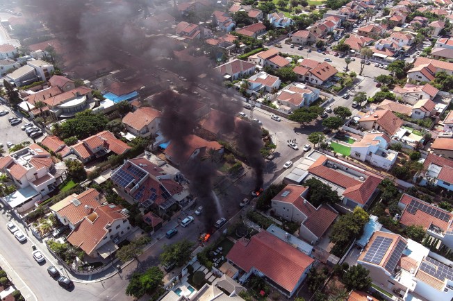 An aerial view of Ashkelon in southern Israel shows vehicles on fire as rockets are launched from the Gaza Strip on October 7, 2023. (Reuters/Ilan Rosenberg)