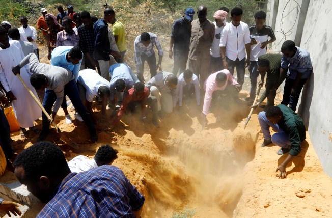 Relatives and Somali journalists bury the body of broadcast reporter Abdiaziz Mohamud Guled, who was killed in suicide bombing attack in the Somali capital of Mogadishu, the capital, on November 20, 2021. The militant group Al-Shabaab claimed responsibility for the attack. (Reuters/Feisal Omar)