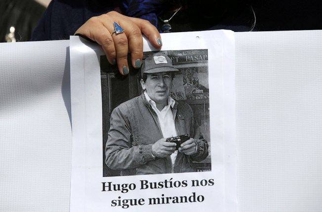A sign reads in Spanish “Hugo Bustíos is still watching.” (AP Photo/Martin Mejia)