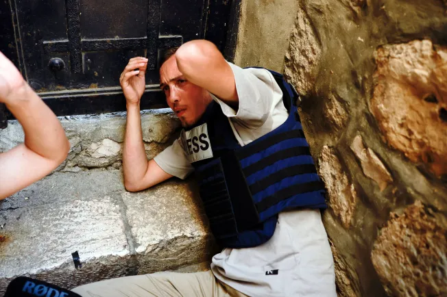 A journalist holds his head after being attacked by participants of the annual Jerusalem Day march by Damascus Gate  in Jerusalem on June 5, 2024. (Photo: Reuters/Ammar Awad)