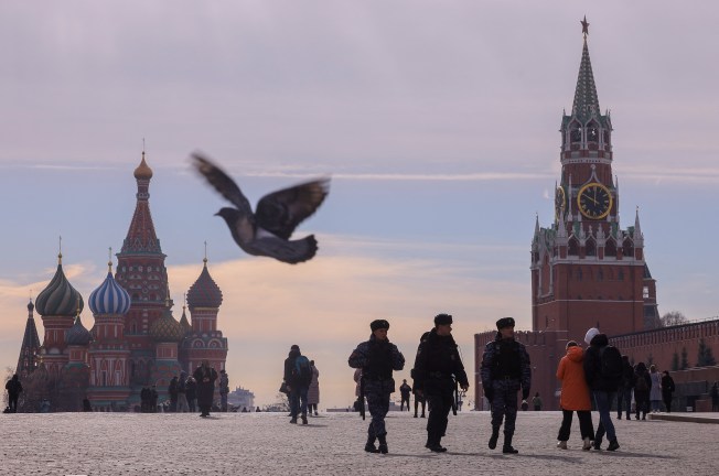 Russian law enforcement officers walk near St. Basil's Cathedral and the Kremlin's Spasskaya Tower on March 20, 2023. (Reuters/Evgenia Novozhenina)