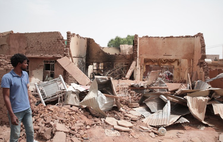 A man walks by a house hit by fighting in Khartoum, Sudan, on April 25, 2023.