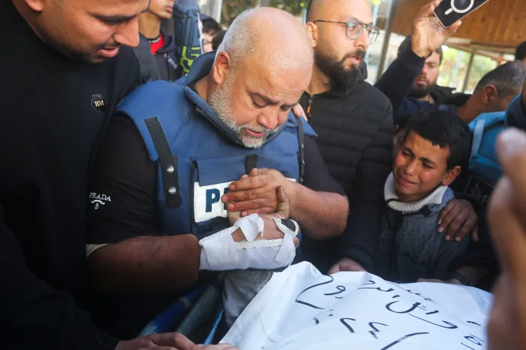 Al-Jazeera journalist Wael Al Dahdouh holds the hand of his son Hamza, who also worked for Al-Jazeera and who was killed in an Israeli strike in southern Gaza on January 7, 2024.