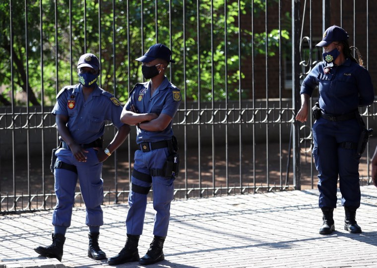 Police officers stand outside a court in Free State province, South Africa, on November 13, 2020.