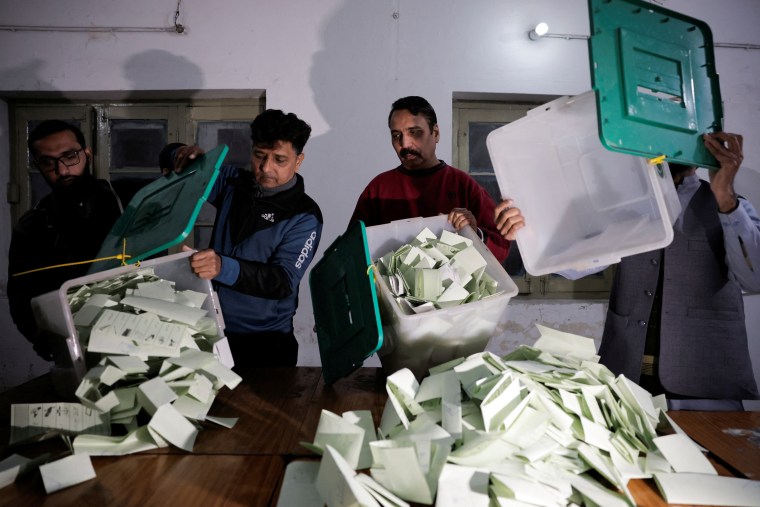 Polling station staff empty a ballot box after polls closed during the general election, in Lahore, Pakistan, on February 8, 2024.