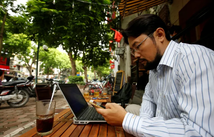 Vietnamese blogger and activist Nguyen Chi Tuyen, also known as Anh Chi, searches the internet on his phone in a cafe in Hanoi, Vietnam, on August 25, 2017.